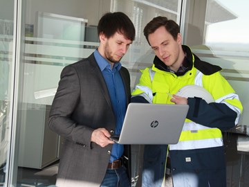 Mitarbeiter aus technischem und kaufmännischen Bereich tauschen sich am Laptop über Informationen aus Mitarbeiter aus technischem und kaufmännischen Bereich tauschen sich am Laptop über Informationen aus