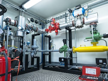 Raum mit Leitungen, Rohren und Messanzeigen Raum mit Leitungen, Rohren und Messanzeigen